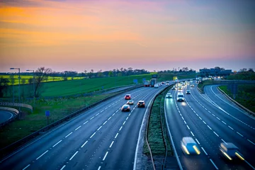 Foto op Aluminium Colourful sunset at M1 motorway near Flitwick junction with blurry cars in United Kingdom © offcaania
