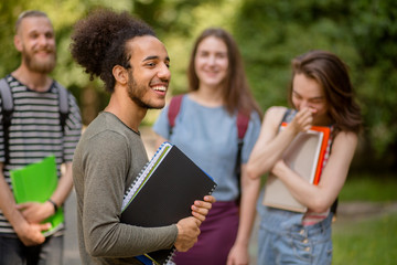 Group of college students latinamerican boy on foreground. Young people having fun, standing in university park.