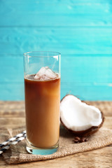 Glass of cold tasty coconut coffee on table