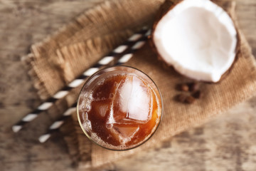 Glass of cold tasty coconut coffee on table