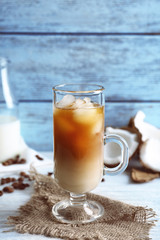 Glass of cold tasty coconut coffee on table