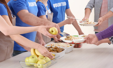 Young volunteers serving food to homeless people