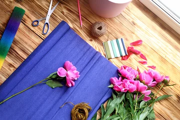 Photo sur Plexiglas Fleuriste Workplace of florist with fresh peonies and wrapping paper on wooden table