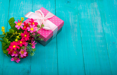 Gift boxes with bow and flowers on wood background. Decoration.