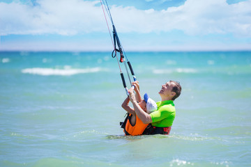 Male kite surfer teaching young boy how to ride kite