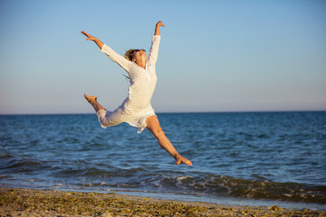 Young woman jumping with joy on beach