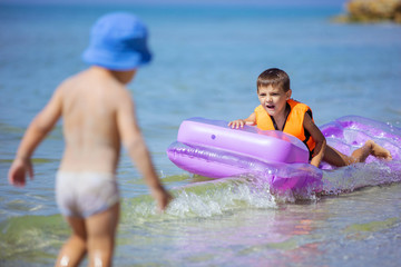 Young boys playing with floating air mattress