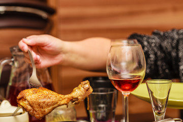 Human hand holding cooked chicken on fork