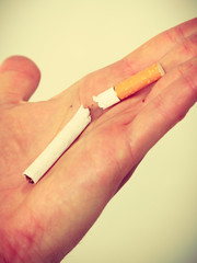 Closeup of broken cigarette on male hand.