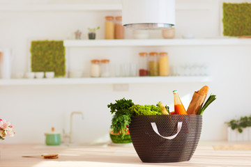shopping bag full of fresh food on kitchen desk