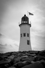 A black and white photograph of an isolated lighthouse