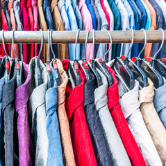 Close up different colorful shirts hanging on rack