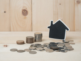 Money coins stack growing with red house on wood background. Business growth investment and financial concept ideas.Real estate investment. House and coins on table.Save money with stack coin .