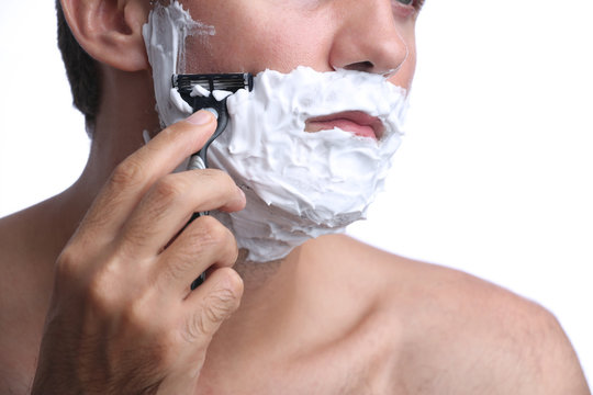 Young man shaving beard