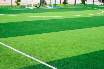 Photo of a green synthetic grass sports field with white line shot from above