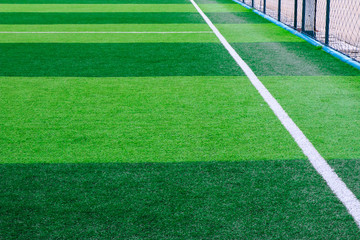Fototapeta na wymiar Photo of a green synthetic grass sports field with white line shot from above