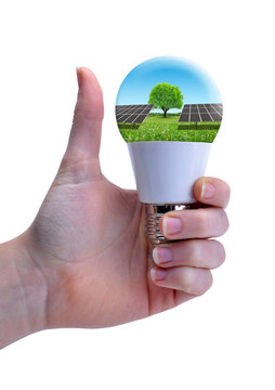 Hand with thumb up holding eco LED bulb with solar panel isolated on a white background. Energy saving lamp.