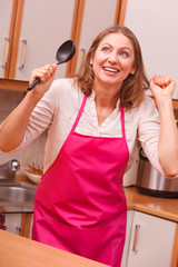 Housewife with ladle in kitchen