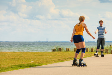 Young couple on roller skates riding outdoors