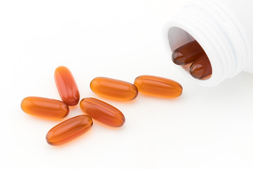 top view of gel pills with plastic bottle on white background
