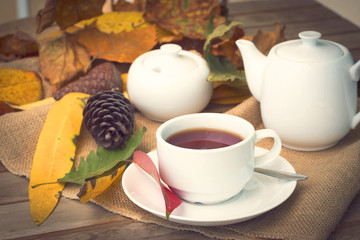 Autumn leafs with cup of tea