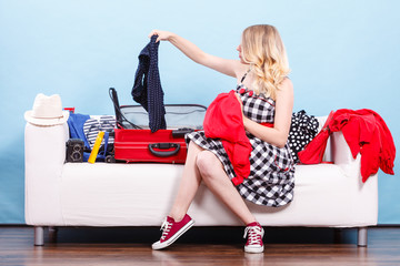 Woman choosing things to pack into suitcase