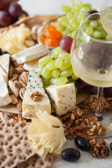 Cheese plate served with grapes, jam, cured melon, crackers and nuts