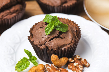 Chocolate cupcakes with mint on wooden table