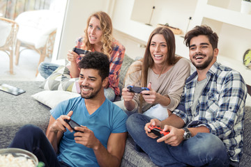 Friends  play video game with joystick at home © ivanko80
