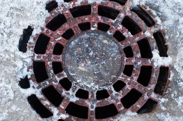 Sewer ventilation hatch with holes in the snow.