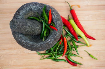 Red and green pepper in a stone mortar.