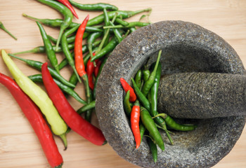 Red and green pepper in a stone mortar.