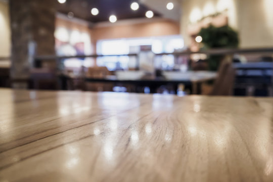 Empty wood table top with blurred cafe restaurant coffee shop interior background