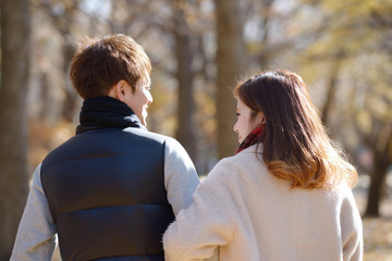 秋の公園でデートする若いカップル