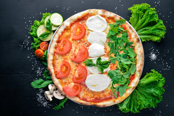 Pizza with vegetables and mozzarella. On a wooden background. Top view. Free space for your text.