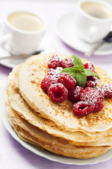 Stack of Russian-style pancakes with raspberries