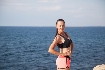 Fototapeta na wymiar Sports girl is engaged in fitness on the beach