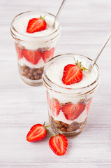 Breakfast with strawberry and chocolate balls corn flakes on white wood board.