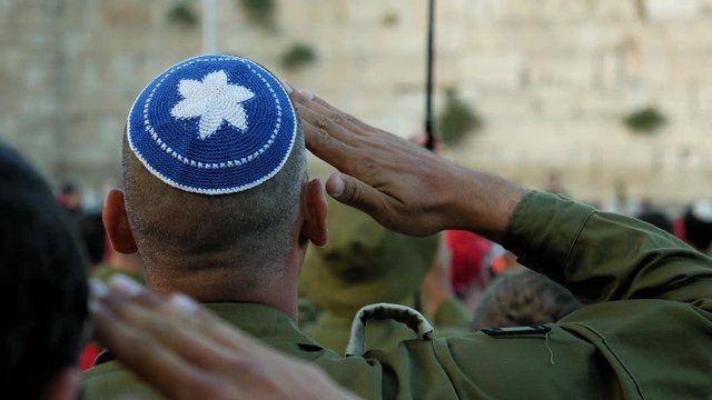 Israeli soldier military man saluting to the Western wall in Jerusalem. Western wall or Wailing wall or Kotel is the most sacred place for all jewish people.