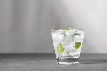 Mojito cocktail with lime and mint in glass on a grey stone background