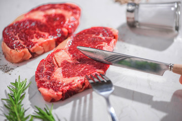 Raw fresh beef on white stone background, top view