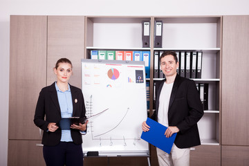 Corporate workers in an office next to a flip chart. Business and finance