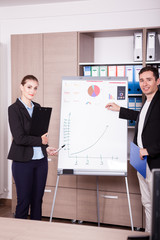 Corporate workers in an office next to a flip chart. Business and finance