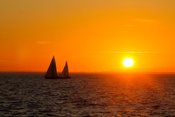 Obraz na płótnie Canvas Two sailboats in a sunset