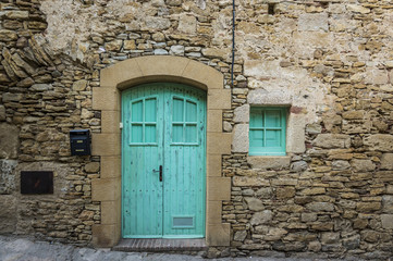 Fototapeta na wymiar Blue door in an old building made of stone