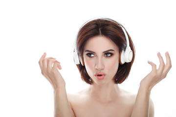 Fototapeta premium Adult adorable fresh looking brunette woman with gorgeous makeup wireless headphones bob hairdo posing against isolated white background showing emotion and facial expression concept.