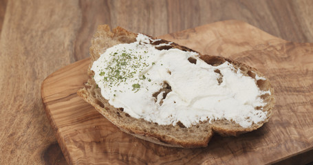 Pan slow motion of arugula fall on rustic bread with ricotta cheese