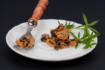 sea food sweet dried clams on dish with fork.