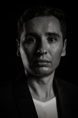 Dramatic portrait of businessman on black background in studio photo in black an white