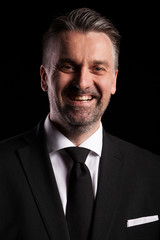 Portrait of adult confident businessman in studio photo on black background